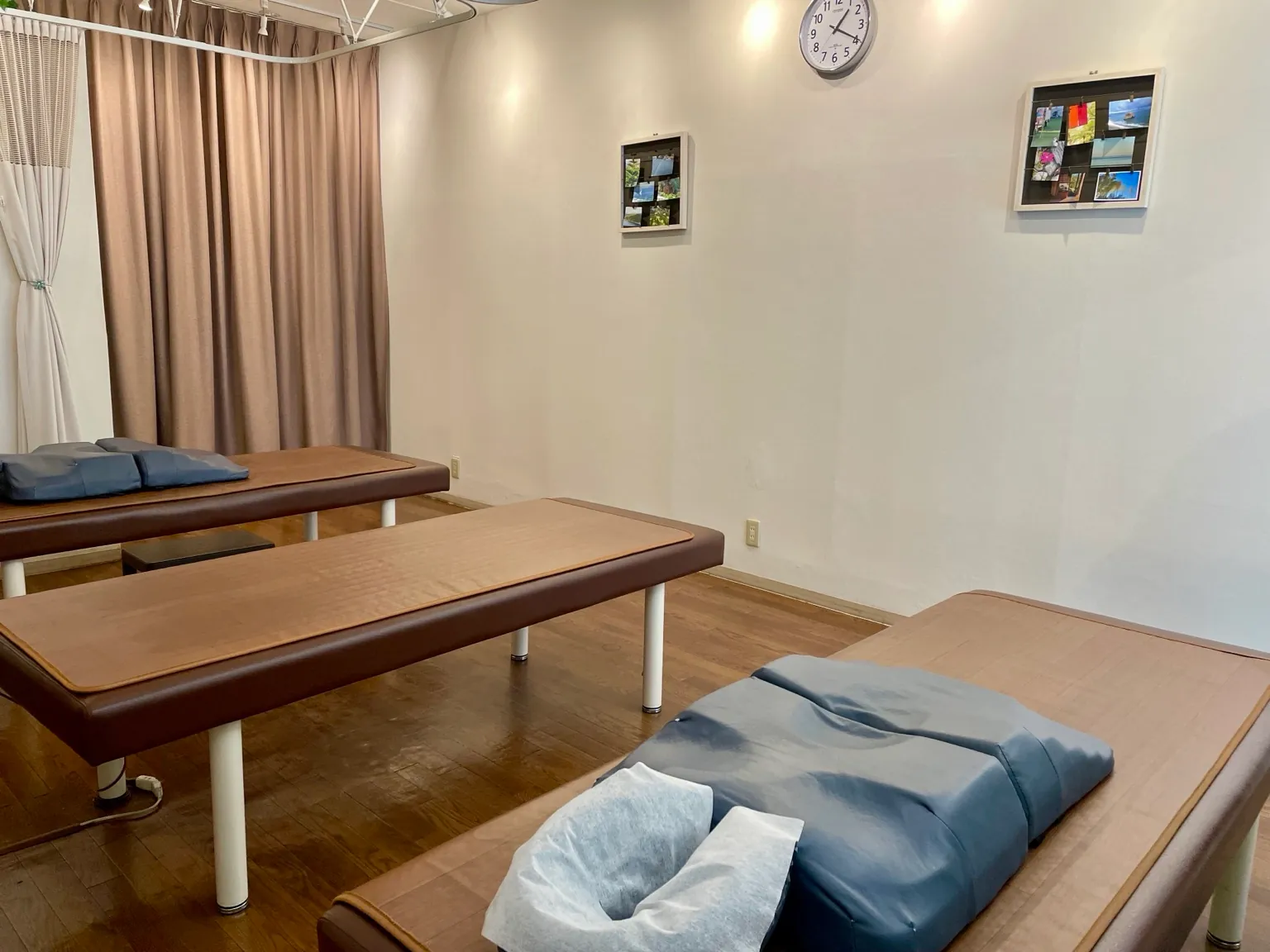 明るい室内に施術ベッドが並び、カーテンで仕切れる勝田台ほぐし接骨院の施術室